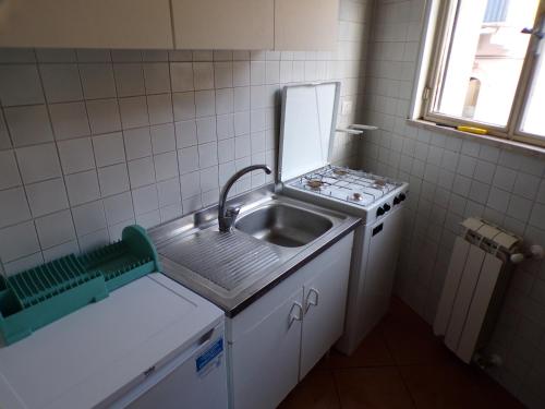 una piccola cucina con lavandino e piano cottura di IL PORTICCIOLO Apartment - Via Umberto 25 a Giardini Naxos