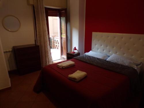 ジャルディーニ・ナクソスにあるIL PORTICCIOLO Apartment - Via Umberto 25の赤いベッドルーム(ベッド1台、タオル2枚付)