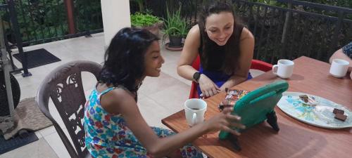 two young girls sitting at a table with a toy at HOMESTAY CAMPING ANURADHAPURA in Anuradhapura