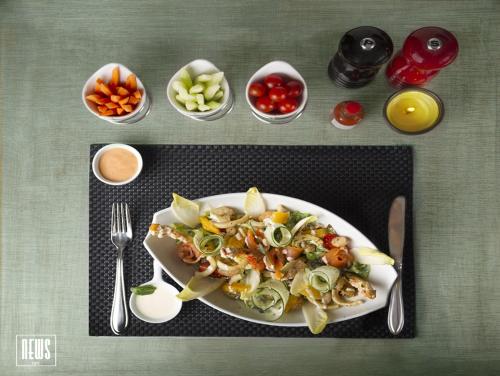 a plate of food with vegetables and fruits on a table at Hotel Lawrence d'Arabie in Marrakech