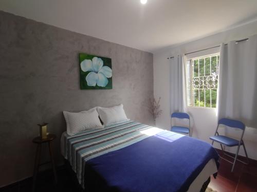 a bedroom with a blue bed and two blue chairs at Pousada Jardins in Macaé