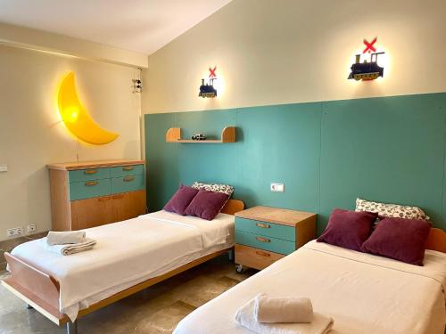 twee bedden in een kamer met blauw en paars bij Confortable Chalet con piscina in Bunyola