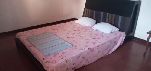 a small bed with a pink blanket and pillows at Heritage Villa colombo7 in Colombo