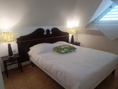 ein Schlafzimmer mit einem Bett mit zwei Lampen auf beiden Seiten in der Unterkunft Appartement Madinina 6 personnes vue sur mer dans village vacances in Sainte-Luce