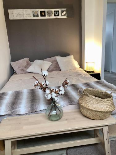 un lit avec un vase de fleurs sur une table dans l'établissement Maison contemporaine en plein cœur de la Touraine, à Chambray-lès-Tours