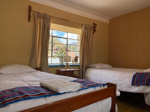 a bedroom with two beds and a window at Casona Checacupe in Checacupe