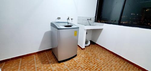 baño pequeño con lavabo y ventana en Departamento en Cuenca, 2 habitaciones y parqueo gratis, en Cuenca