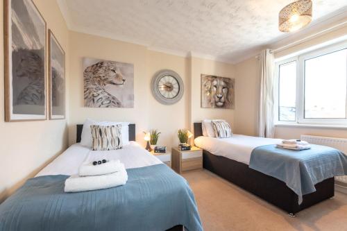 una camera con due letti e una finestra di Cheerful 3-bedroom Douglas house with patio a Southampton