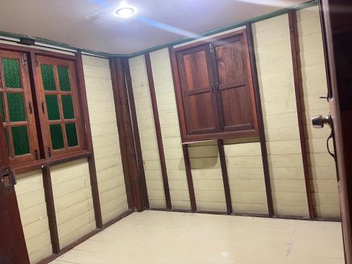 an empty room with two windows and a door at Hillmyna garden home stay in Ko Por