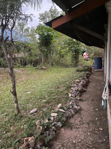 a stone path next to a house with a tree at Hillmyna garden home stay in Ko Por