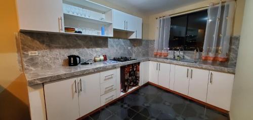 a kitchen with white cabinets and a counter top at Departamento en Cuenca, 2 habitaciones y parqueo gratis in Cuenca