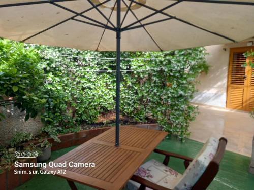 a wooden table with an umbrella on a patio at Room in Nerezine with balcony, Wifi 4827-5 in Nerezine