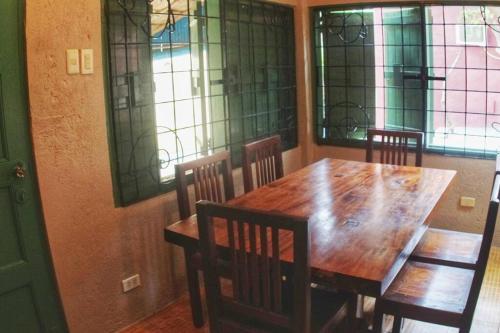 a dining room table and chairs with stained glass windows at Beach House-Casita in Calatagan with pool ( for 6) in Calatagan