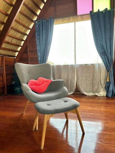 a chair with a red pillow in a room at RuenKijja in Ban Kroen