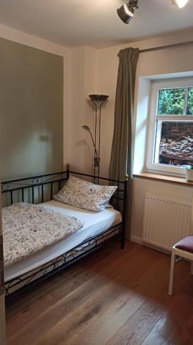 1 dormitorio con cama, ventana y lámpara en FeWo mit Heimatgefühl, en Ratekau