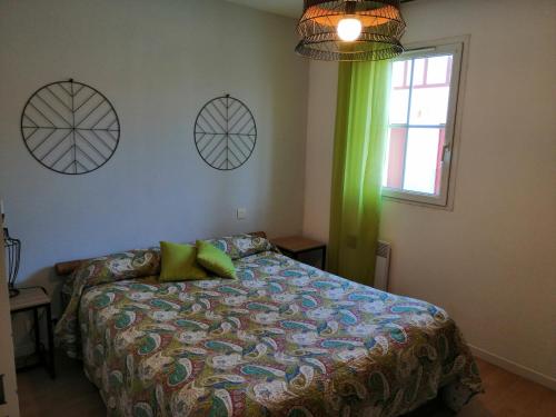 1 dormitorio con 1 cama con cortina verde y ventana en Katixa Apartment en Saint-Pée-sur-Nivelle