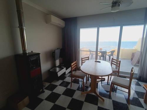 een woonkamer met een tafel en stoelen met uitzicht bij Poseidons Seaview Penthouse in Marsalforn