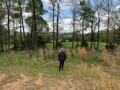 a woman standing in the grass in a field at Caddo Cabin on Collier Creek in Norman