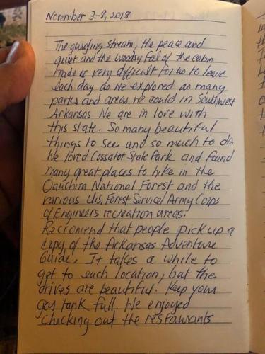 a hand holding a book with handwriting on it at Caddo Cabin on Collier Creek in Norman