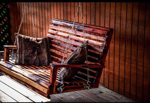 a wooden swing with two bags sitting on it at Caddo Cabin on Collier Creek in Norman