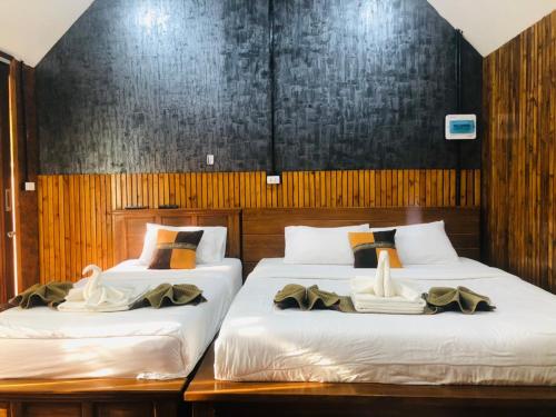 2 Betten in einem Zimmer mit Holzwänden in der Unterkunft กอบสุข รีสอร์ท 2 k14 