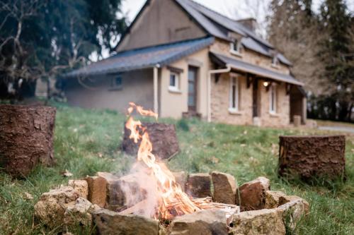 a fire pit in a yard in front of a house at Cottage Breton - Gîte de Charme en Centre Finistère (Situation idéale) in Plonévez-du-Faou