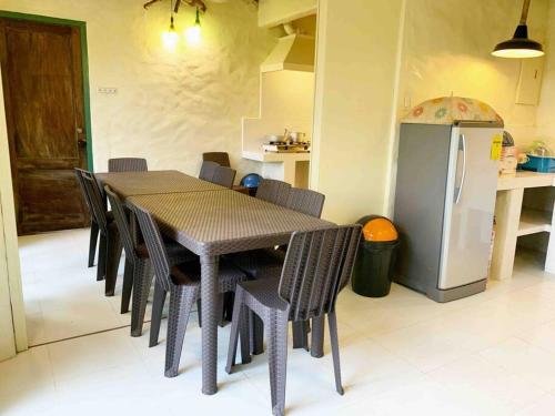 cocina con mesa, sillas y nevera en Capiz Beach Villa w/ pool (entire cottage for 12) en Calatagan