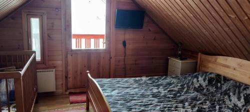 ein Schlafzimmer mit einem Bett in einer Holzhütte in der Unterkunft Kivitasku in Kalajoki