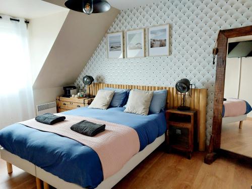 une chambre avec un grand lit avec des draps bleus dans l'établissement Chambres d'hôtes chez l'habitant - Bed & Breakfast homestay, à Huisnes-sur-Mer