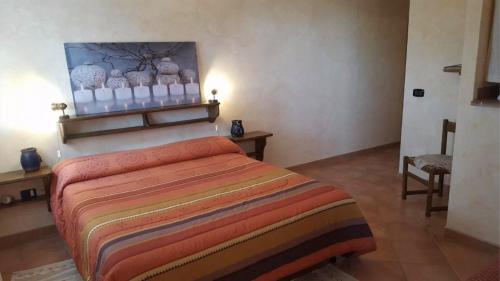 una camera da letto con un letto e un dipinto sul muro di Brezza di Mare a Calasetta