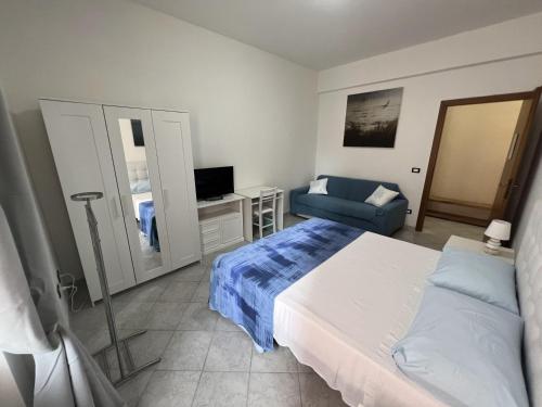 1 dormitorio con 1 cama y 1 sofá azul en Bed and Breakfast Mare Blu, en Civitavecchia
