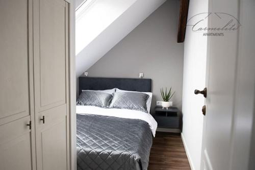 um quarto com uma cama num quarto branco em Spacious sky Carmelite apartment em Vilnius