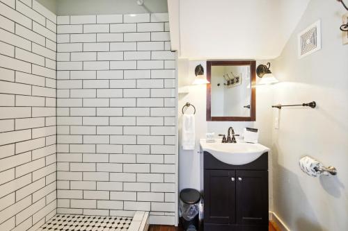 a white bathroom with a sink and a mirror at The Big Kahuna Manor in Galveston