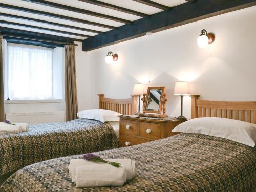 a hotel room with two beds and a mirror at Tyn Y Ffordd in Llanymawddwy