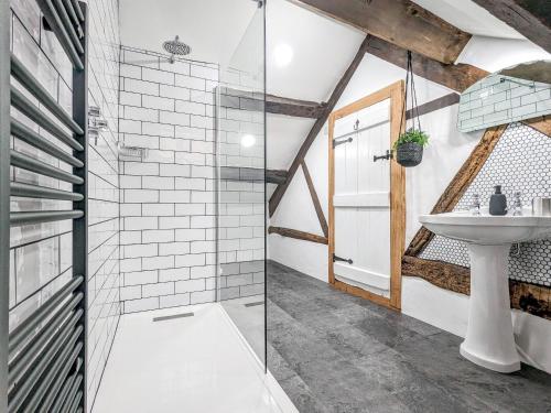 a bathroom with a sink and a glass shower at Tyn Y Ffordd in Llanymawddwy