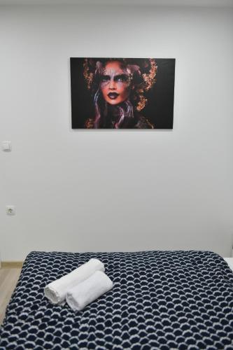 a bed with two towels and a picture on the wall at Apartman Lucia in Ðakovo