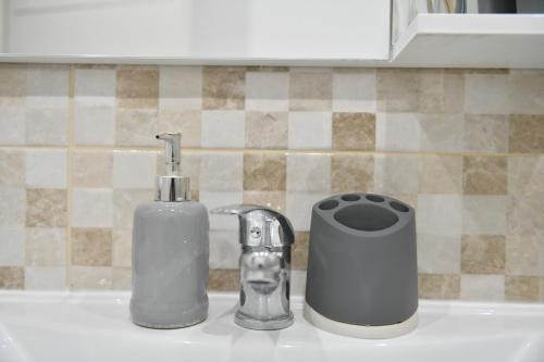 a sink with a soap dispenser and a toothbrush at Apartman Lucia in Ðakovo