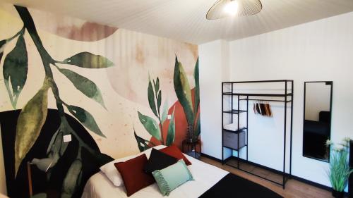 una sala de estar con un mural de plantas en la pared en Villa Papillon***. Location appartement 1er étage., en Ronce-les-Bains