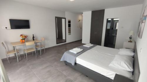 a bedroom with a bed and a table with chairs at Nissi avenue studio in Ayia Napa