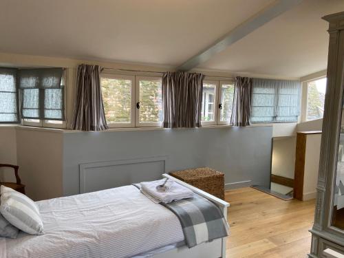 um quarto com uma cama e algumas janelas em Maison de Corinne em Bergerac