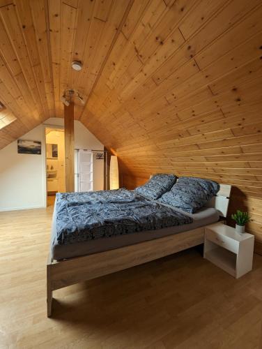 a bed in a room with a wooden ceiling at Pension Larifari in Drees