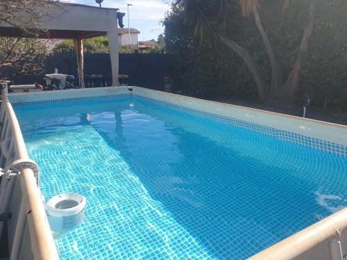 ein großer Pool mit einem blauen, an den Boden gewickelten und verputzten Schwimmbecken in der Unterkunft B&B La Dolce Vita in Flumini di Quartu