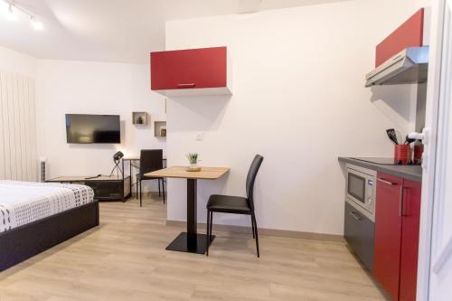 Cette chambre comprend un lit, une table et une cuisine. dans l'établissement Le Brivet ☆ Hypercentre ☆ Parking ☆ Terrasse, à Pontchâteau