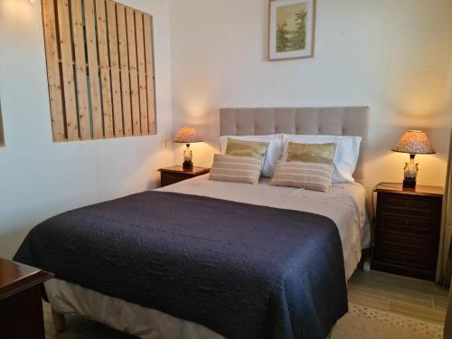 een slaapkamer met een groot bed met 2 nachtkastjes bij Desertas View Apartment in Machico