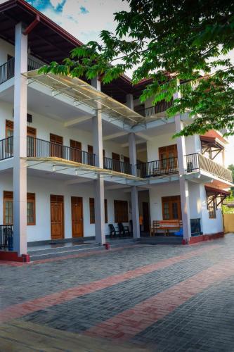 a large building with a courtyard in front of it at Rathna Holiday Resort in Kataragama