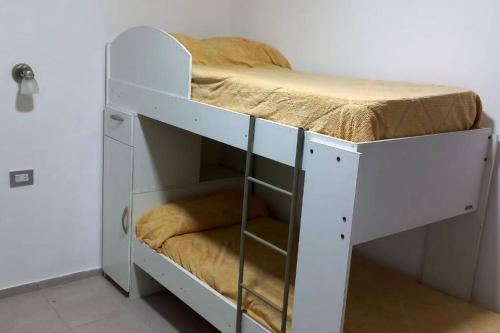a white bunk bed in a room with a bed at Cabaña de campo La Tabanerina in Salto de las Rosas
