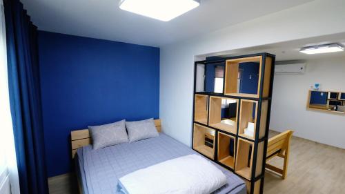 1 dormitorio con cama y pared azul en Ein House, en Gongju