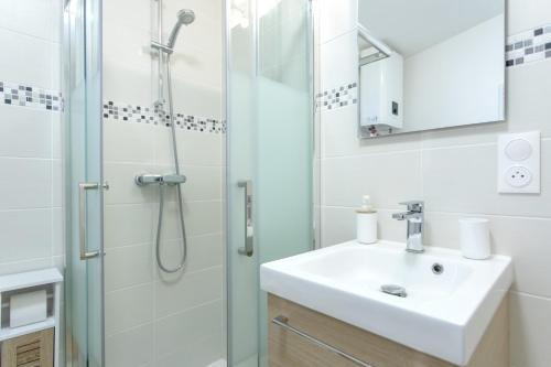 uma casa de banho com um lavatório e um chuveiro em Le Brivet ☆ Hypercentre ☆ Parking ☆ Terrasse em Pontchâteau