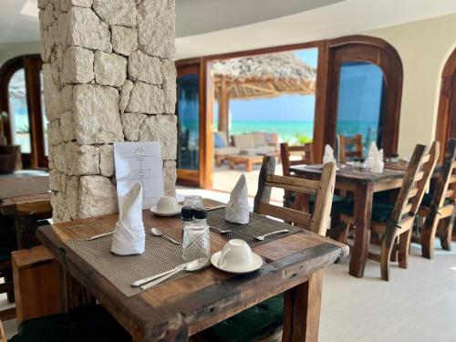 a wooden table with napkins and utensils on it at Zula Zanzibar in Paje