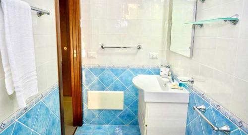 un bagno blu e bianco con un lavandino e uno specchio di Perla Blu a Cefalù
